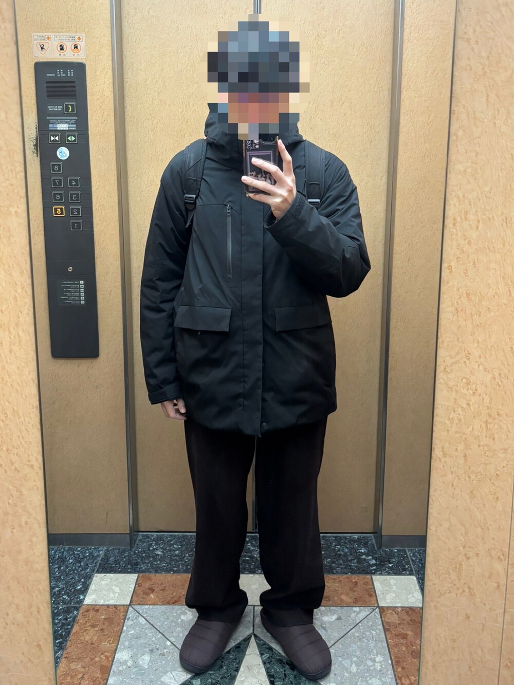 ブラウン系のサンダル、ブラウン系のカーディガン/ボレロ、ブラック系のブルゾンを着用したメンズの冬コーディネートの2枚目の写真