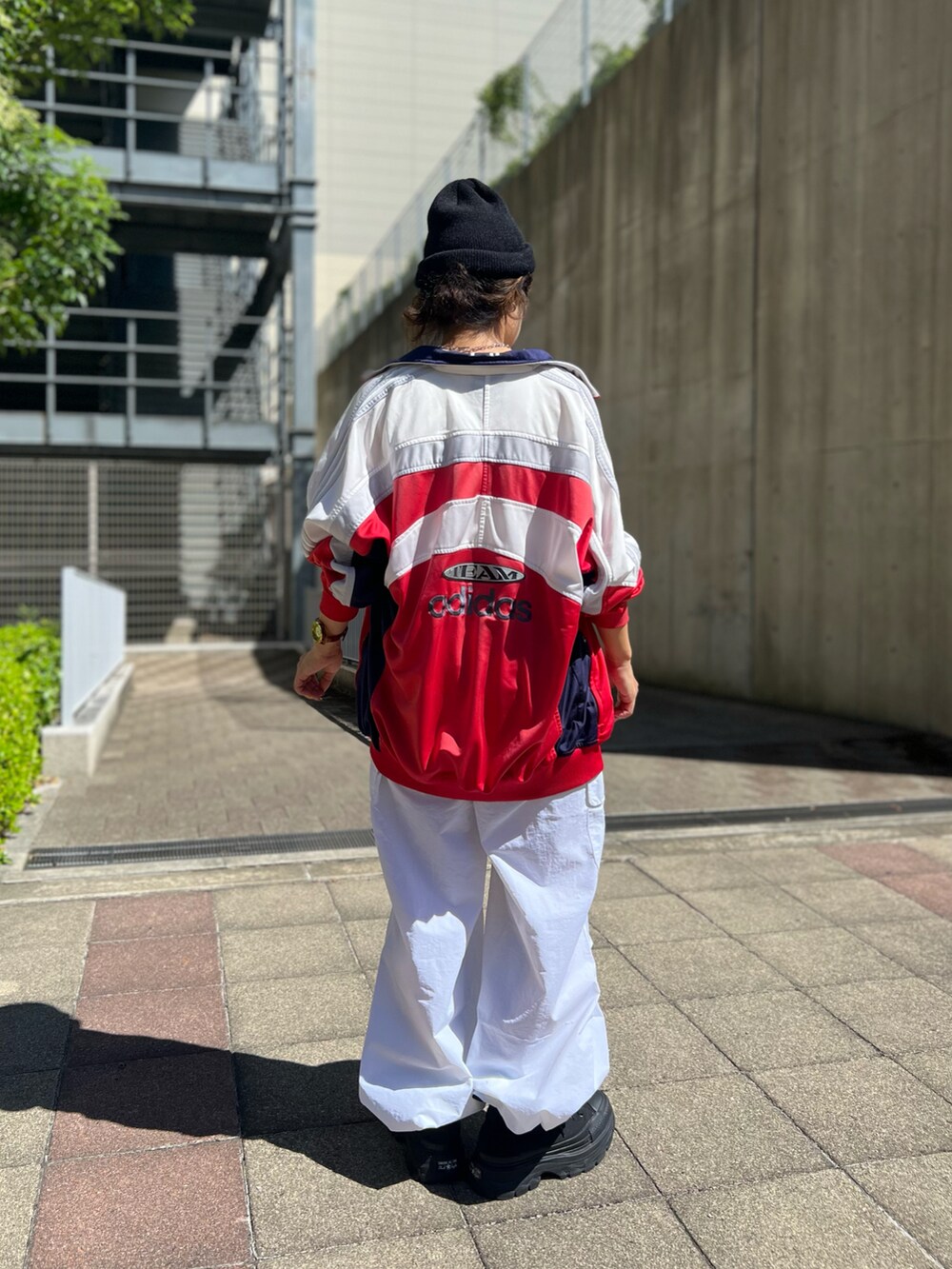 ブラック系のスニーカー、ホワイト系のカーゴパンツ、ホワイト系のタンクトップを着用したレディースの夏コーディネートの2枚目の写真