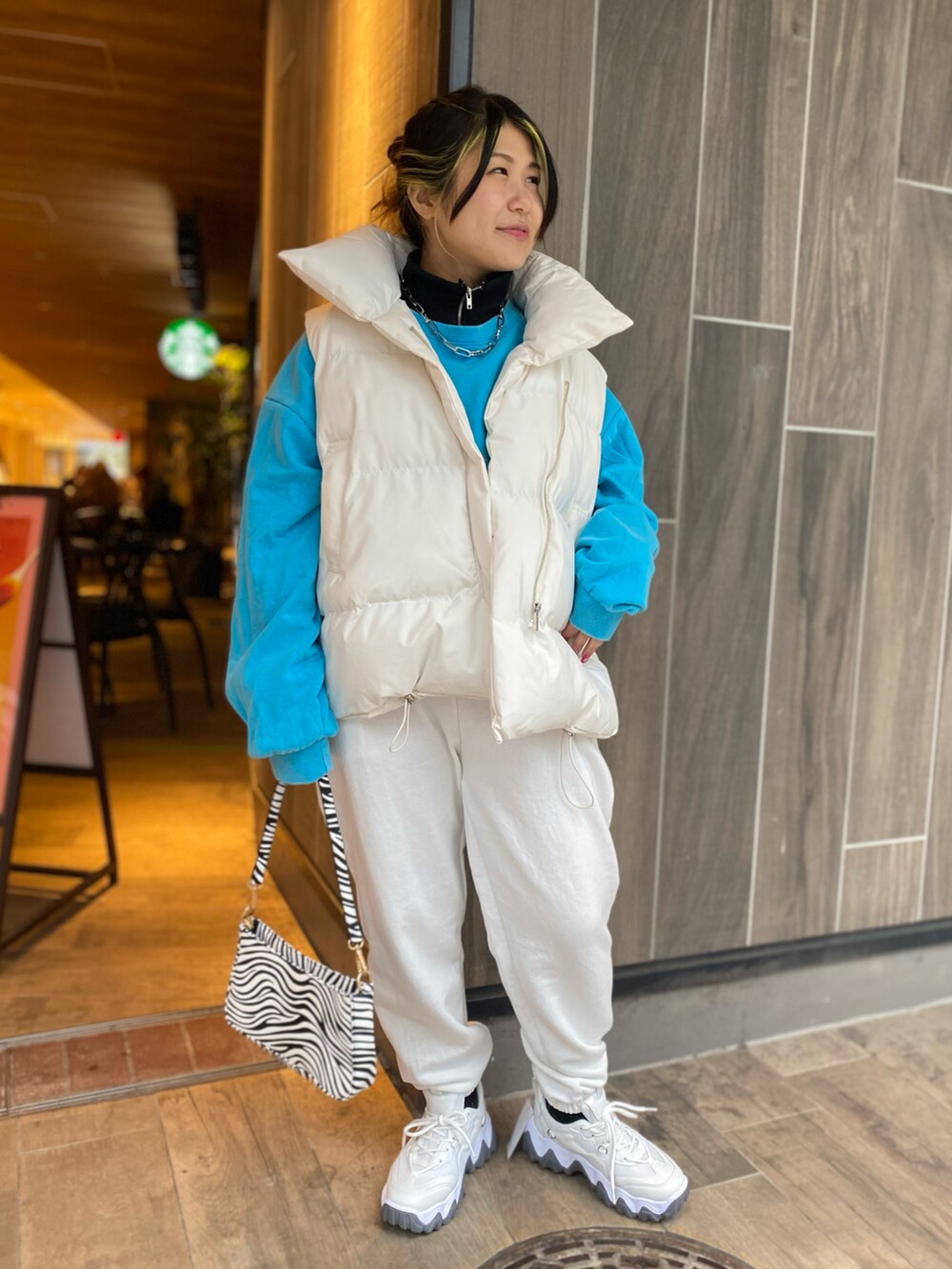 ブルー系のスウェット、ホワイト系のスウェットパンツ、その他のハンドバッグを着用したレディースの冬コーディネートの2枚目の写真