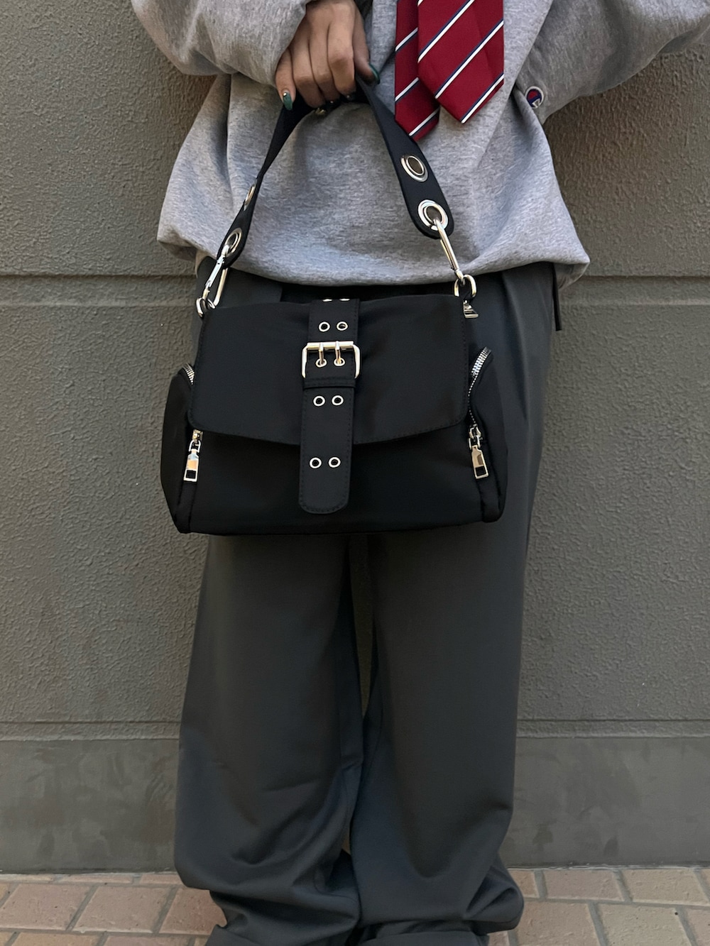 ブラック系のショルダーバッグ、グレー系のスラックス、グレー系のスウェットを着用したレディースの春コーディネートの4枚目の写真