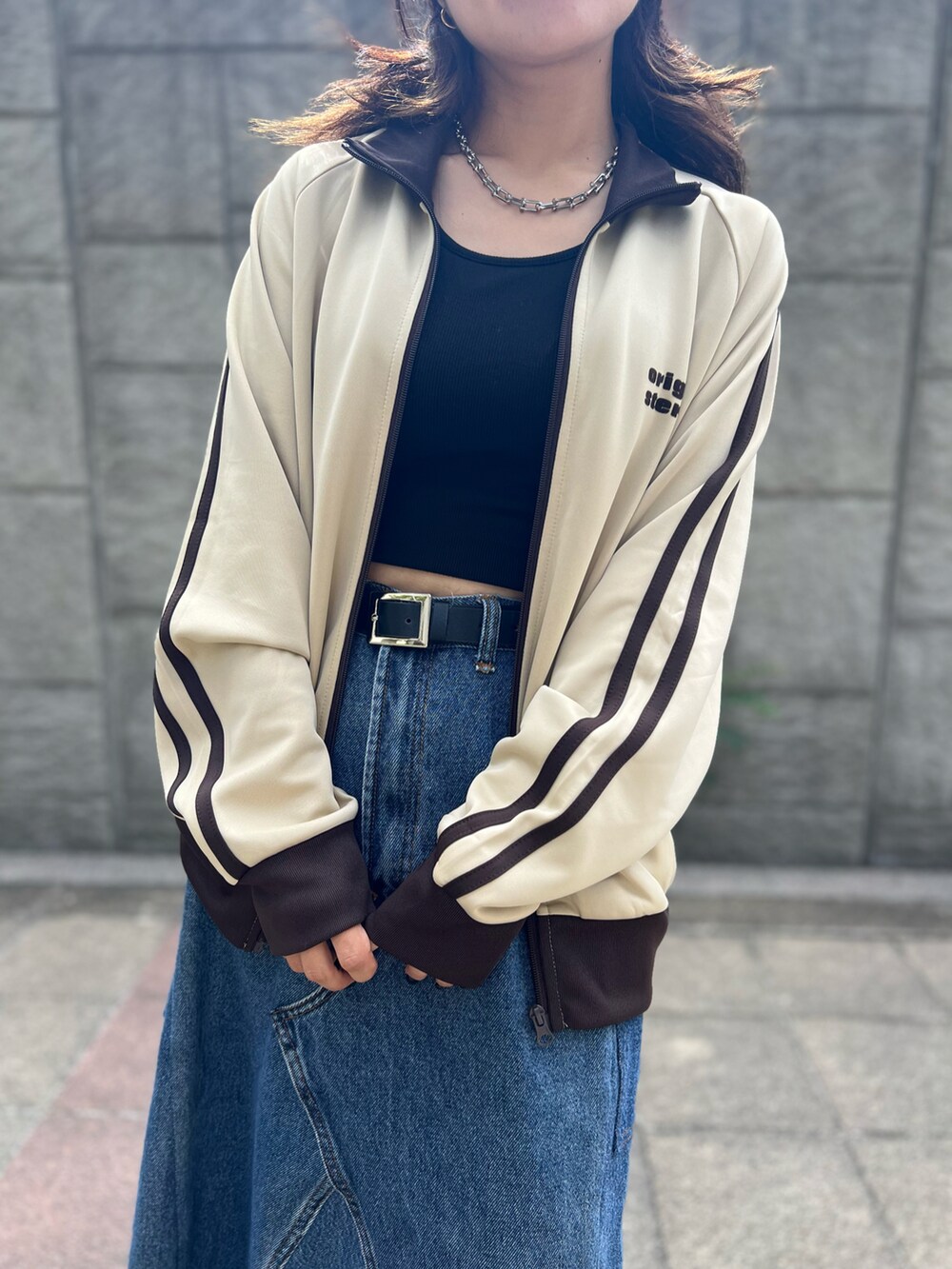 ブラック系のスニーカー、ブラック系のタンクトップ、ベージュ系のジャージを着用したレディースの秋コーディネートの2枚目の写真