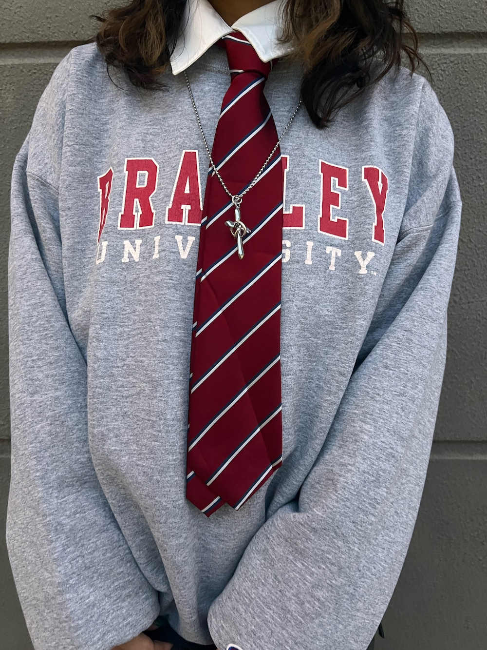 ブラック系のショルダーバッグ、グレー系のスラックス、グレー系のスウェットを着用したレディースの春コーディネートの2枚目の写真