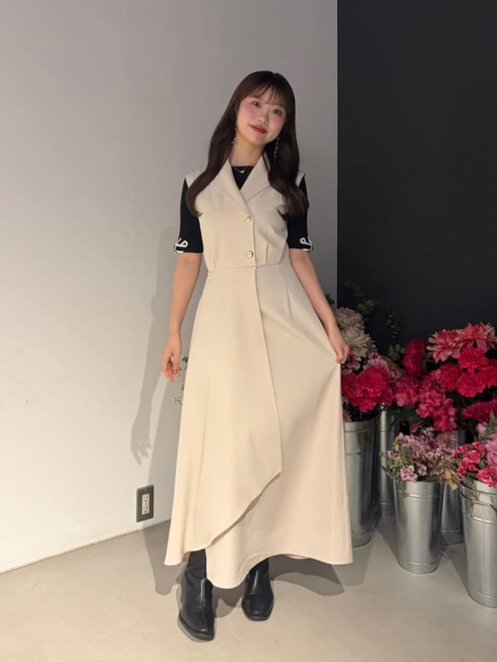 ホワイト系のワンピース、ブラック系のニット/セーターを着用したレディースの春コーディネートの2枚目の写真