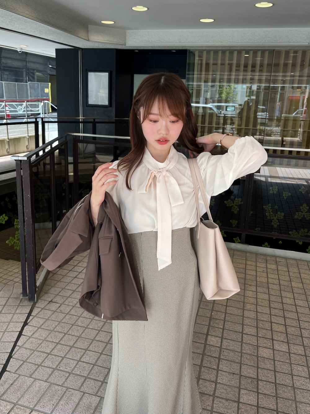 ブラウン系のテーラードジャケット、ホワイト系のシャツ/ブラウス、ホワイト系のパンプスを着用したレディースの夏コーディネートの2枚目の写真