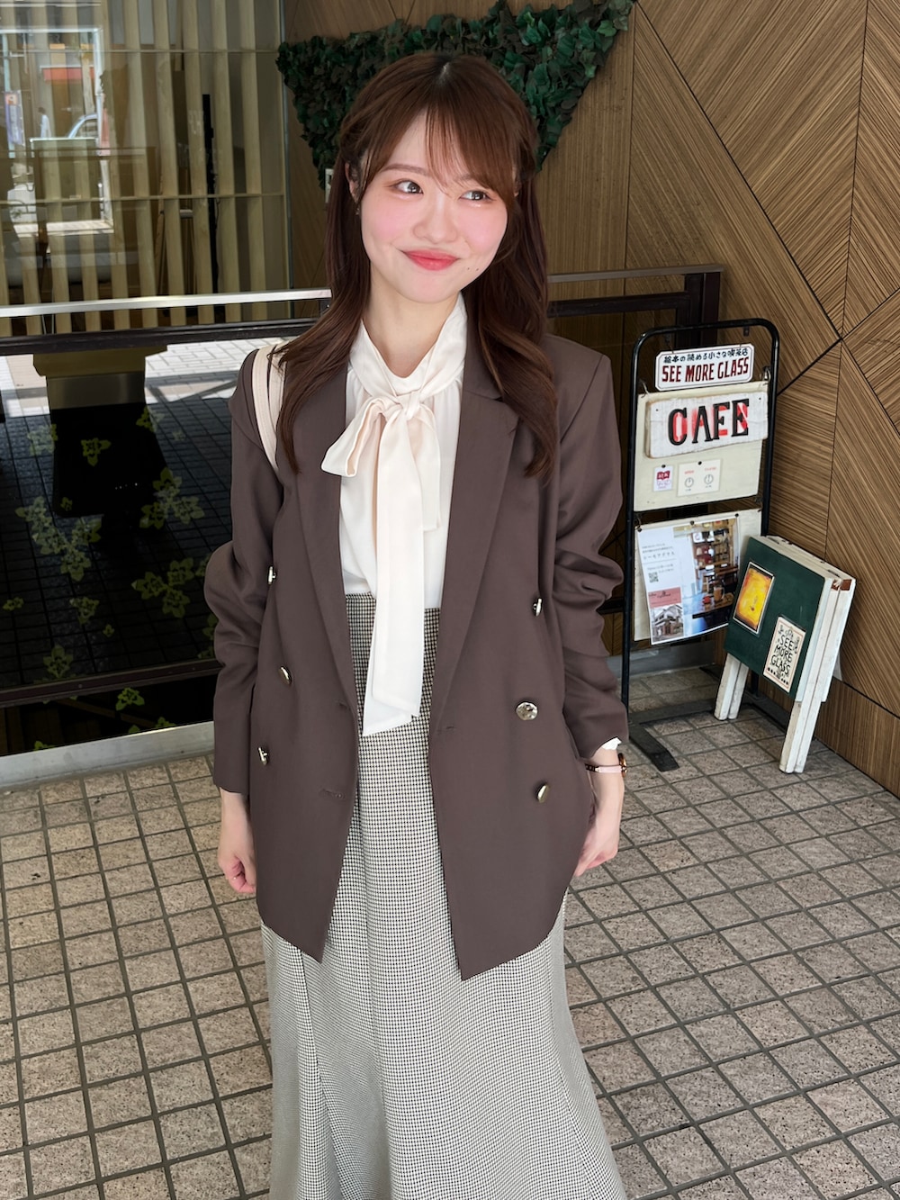 ブラウン系のテーラードジャケット、ホワイト系のシャツ/ブラウス、ホワイト系のパンプスを着用したレディースの夏コーディネートの3枚目の写真