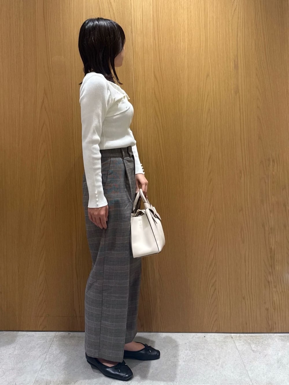 ホワイト系のニット/セーター、ブラウン系のその他パンツ、ホワイト系のトートバッグを着用したレディースの秋コーディネートの2枚目の写真
