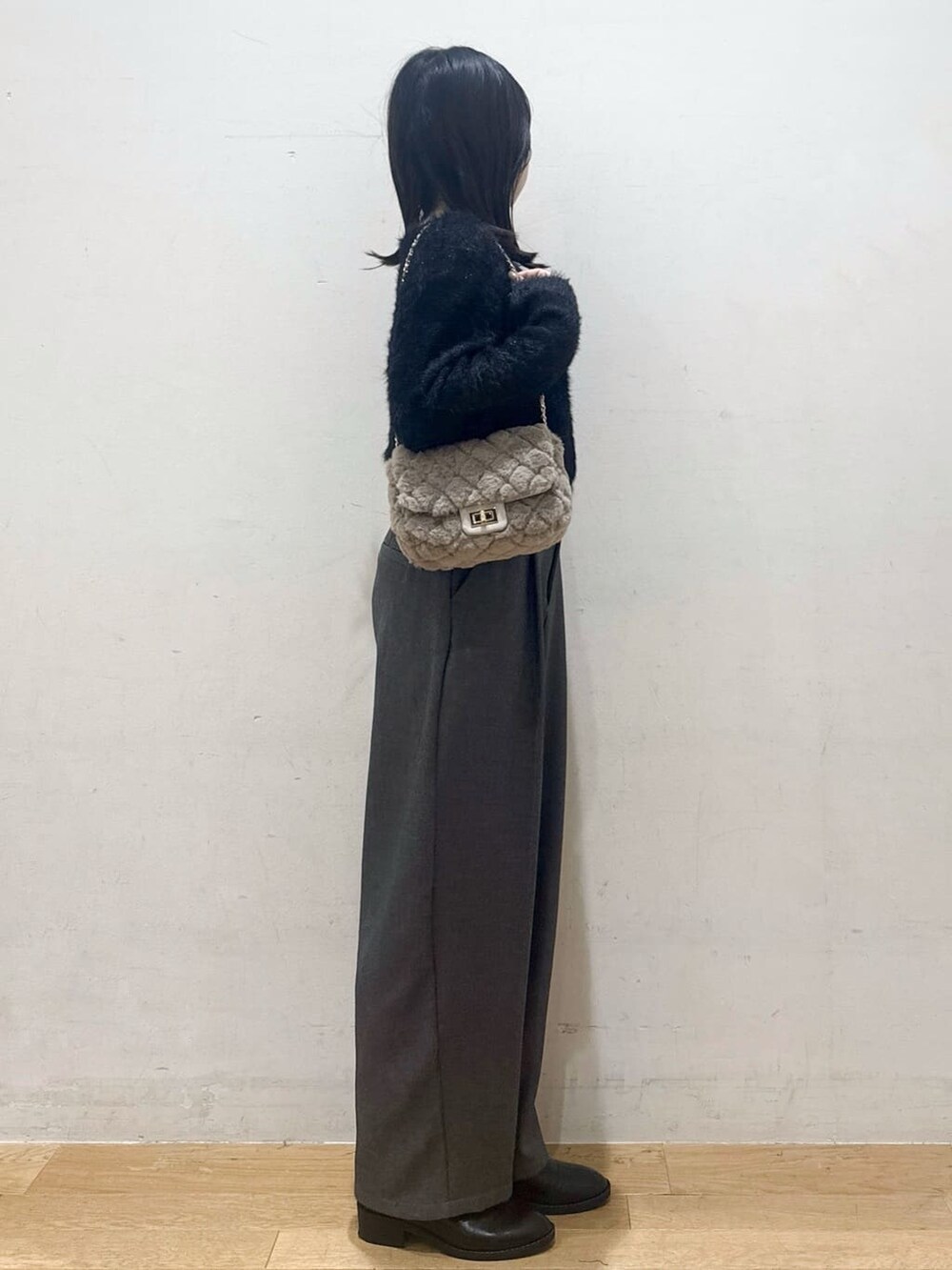 ブラック系のニット/セーター、グレー系のその他パンツ、ブラック系のブーツを着用したレディースの秋コーディネートの2枚目の写真