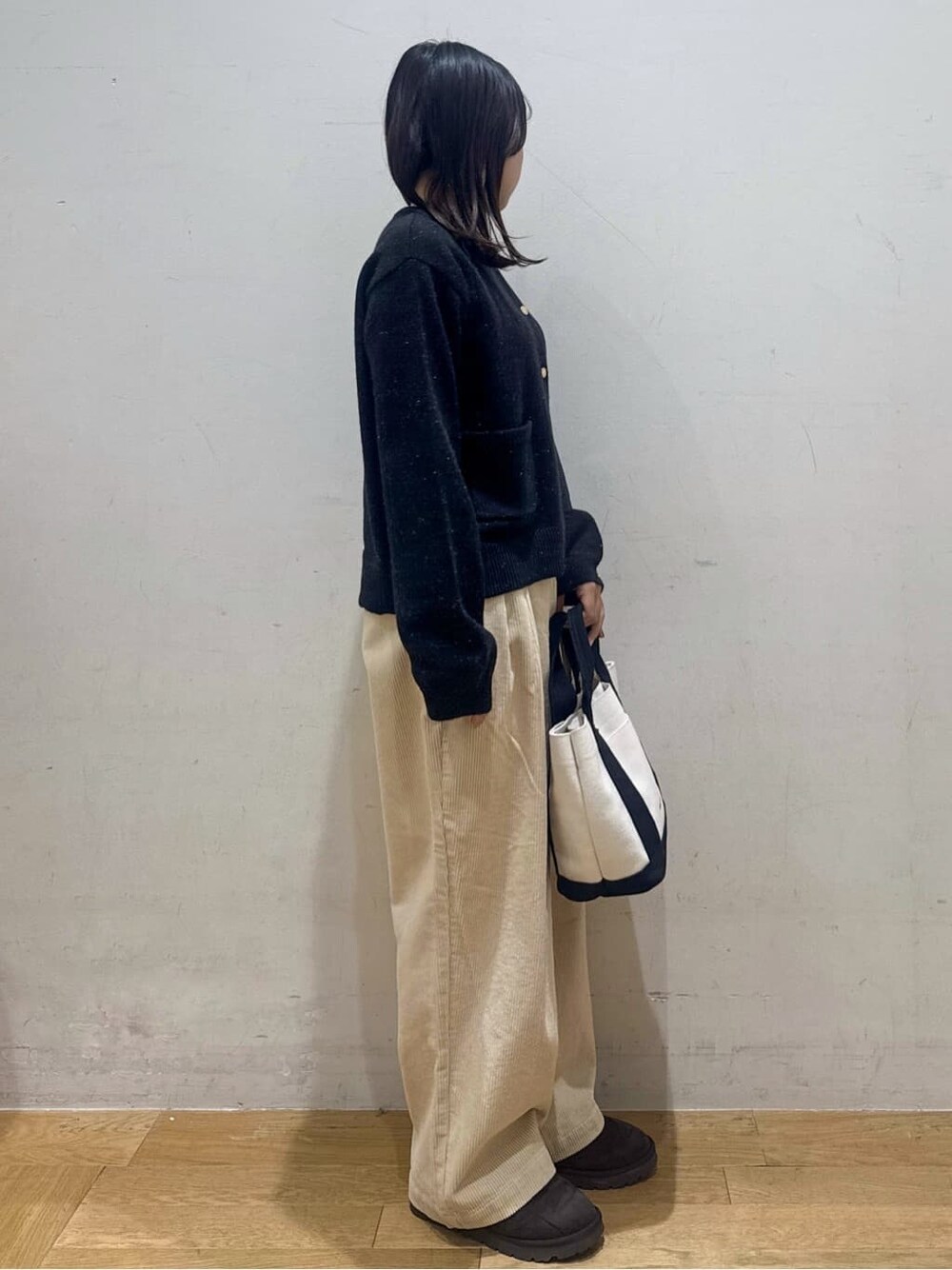 ブラック系のカーディガン/ボレロ、ホワイト系のその他パンツ、ベージュ系のトートバッグを着用したレディースの冬コーディネートの2枚目の写真