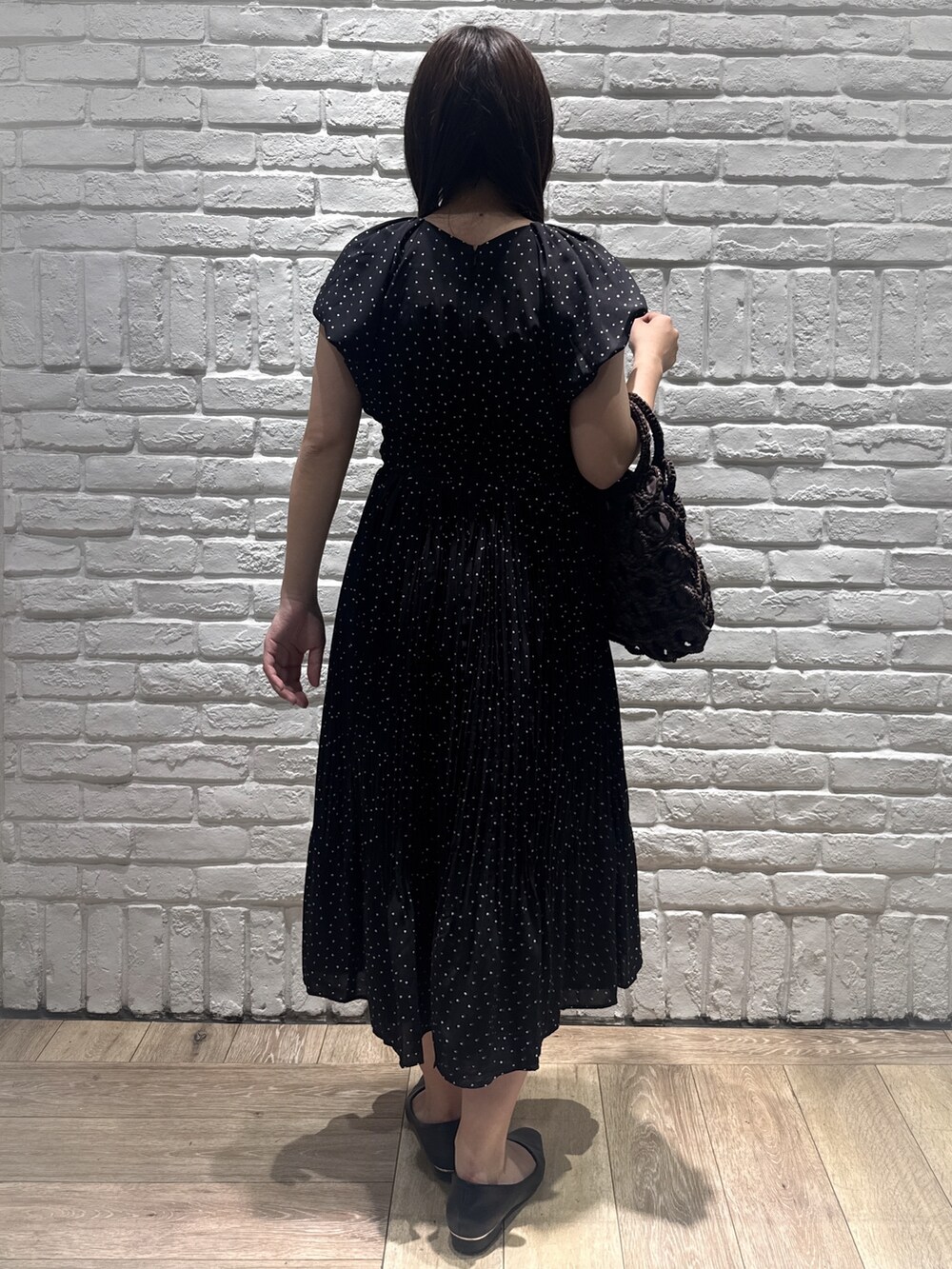 ブラック系のパンプス、ブラウン系のハンドバッグ、ブラック系のワンピースを着用したレディースの春コーディネートの4枚目の写真