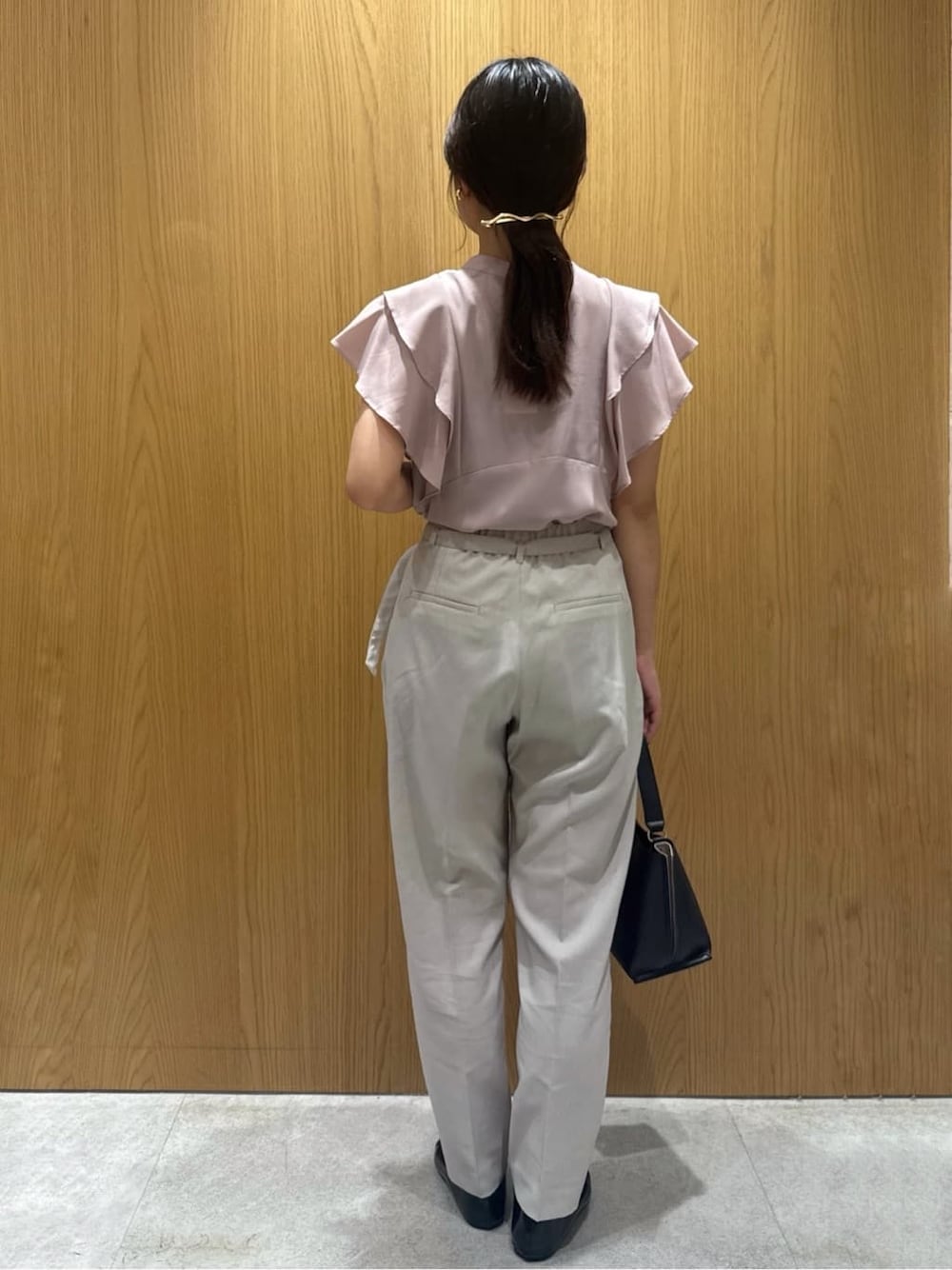 ピンク系のシャツ/ブラウス、ベージュ系のその他パンツ、ブラック系のショルダーバッグを着用したレディースの夏コーディネートの3枚目の写真