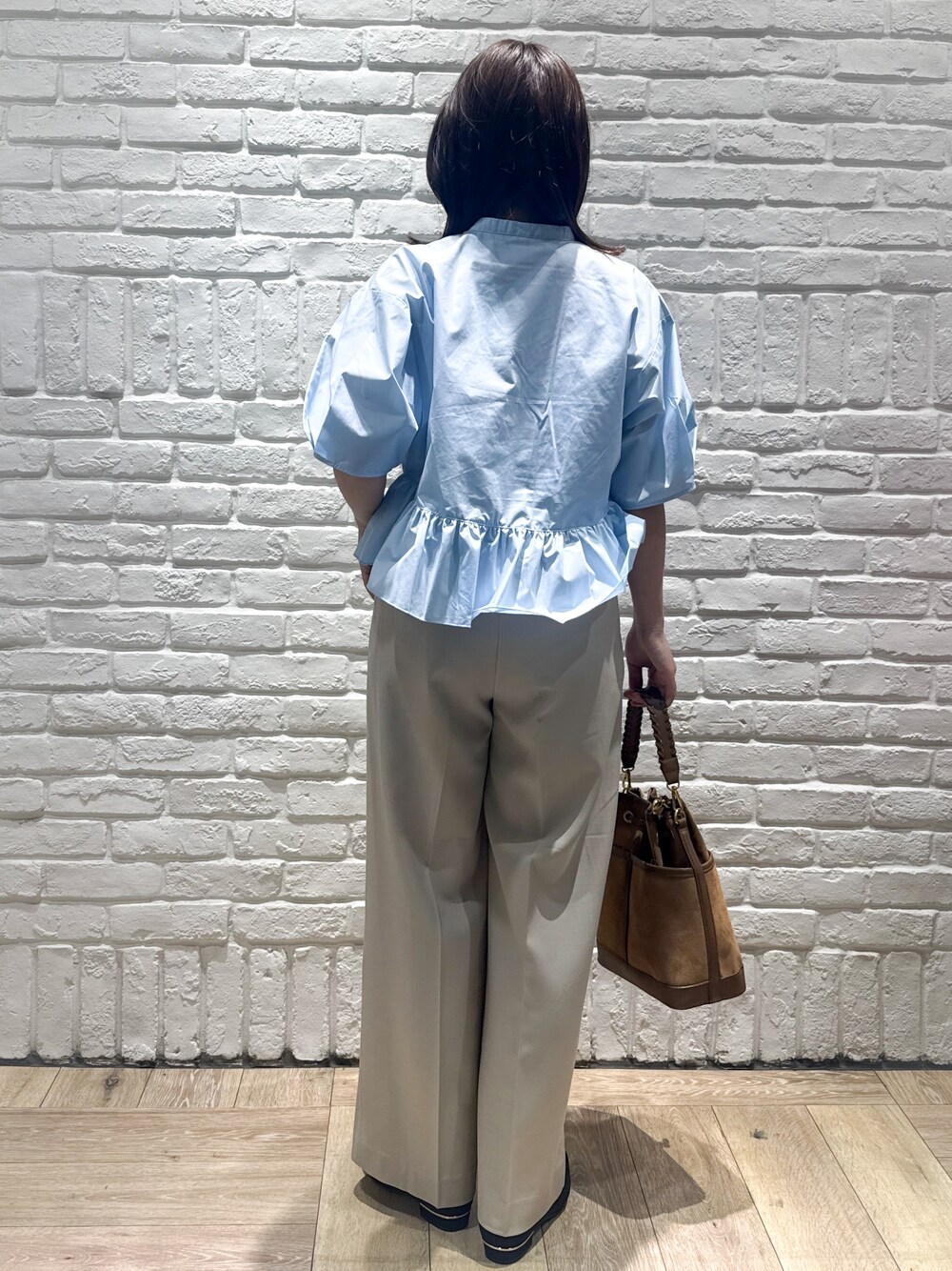ブルー系のシャツ/ブラウス、ベージュ系のその他パンツ、ブラウン系のショルダーバッグを着用したレディースの春コーディネートの3枚目の写真