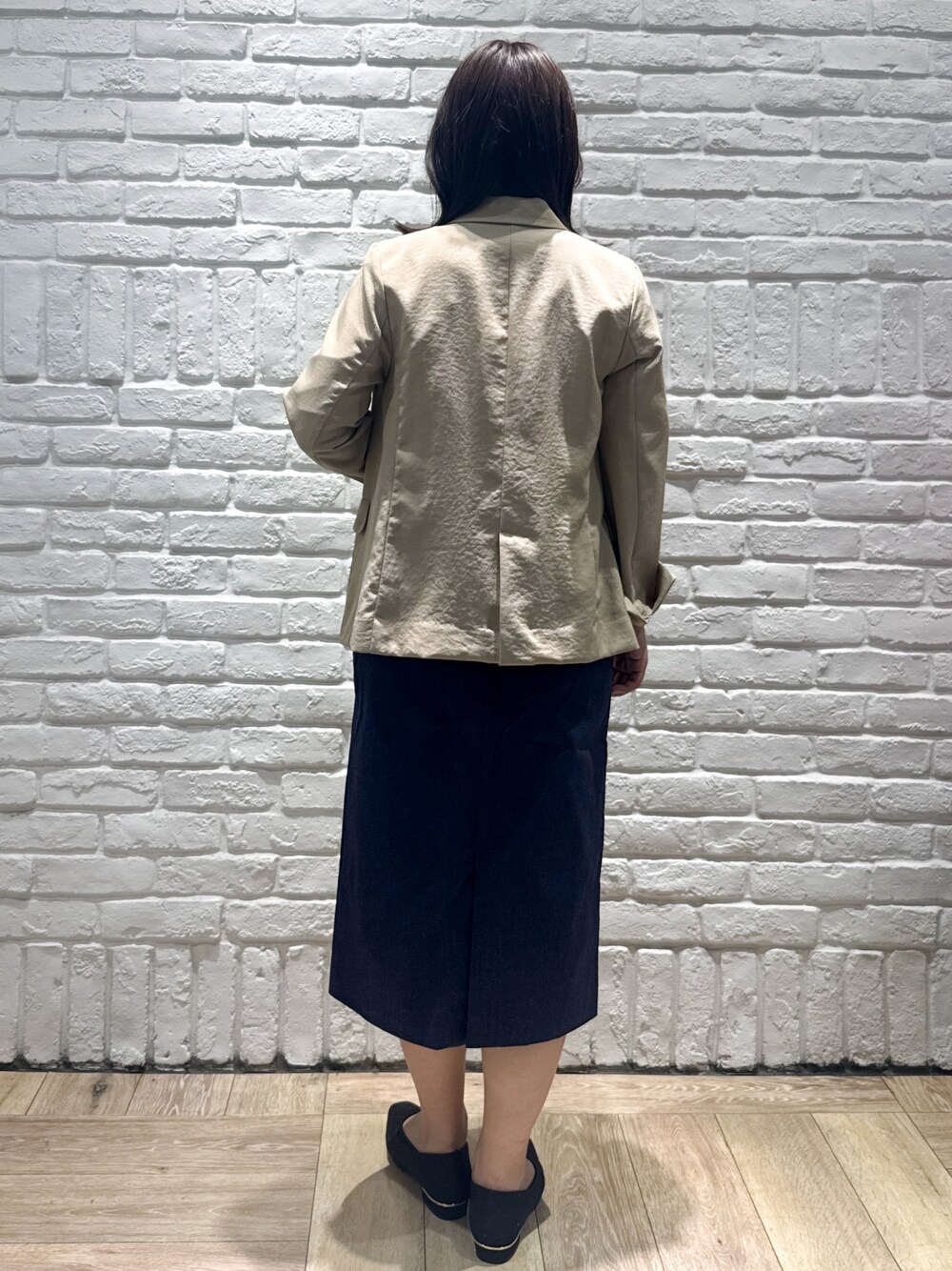 ベージュ系のテーラードジャケット、ホワイト系のTシャツ/カットソー、ブルー系のスカートを着用したレディースの春コーディネートの3枚目の写真