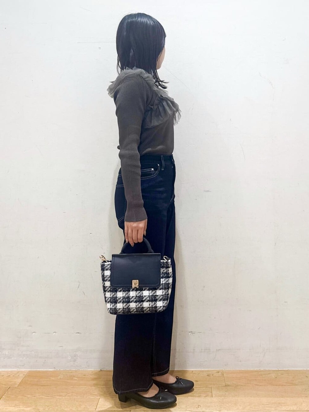 グレー系のニット/セーター、ブルー系のその他パンツ、ブラック系のハンドバッグを着用したレディースの秋コーディネートの2枚目の写真
