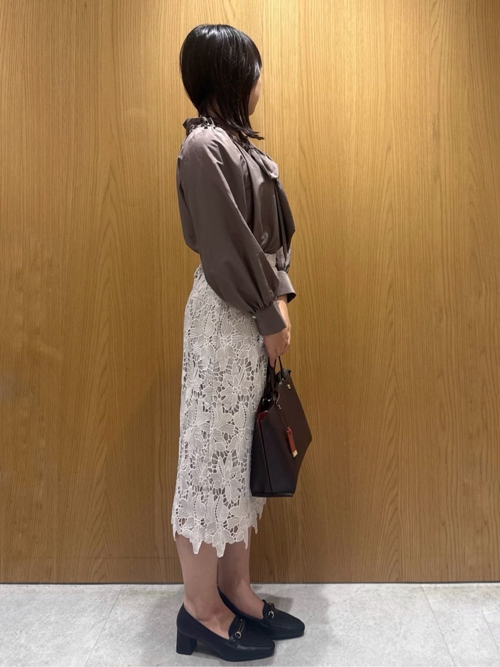 ブラウン系のシャツ/ブラウス、ベージュ系のスカート、ブラウン系のトートバッグを着用したレディースの秋コーディネートの3枚目の写真