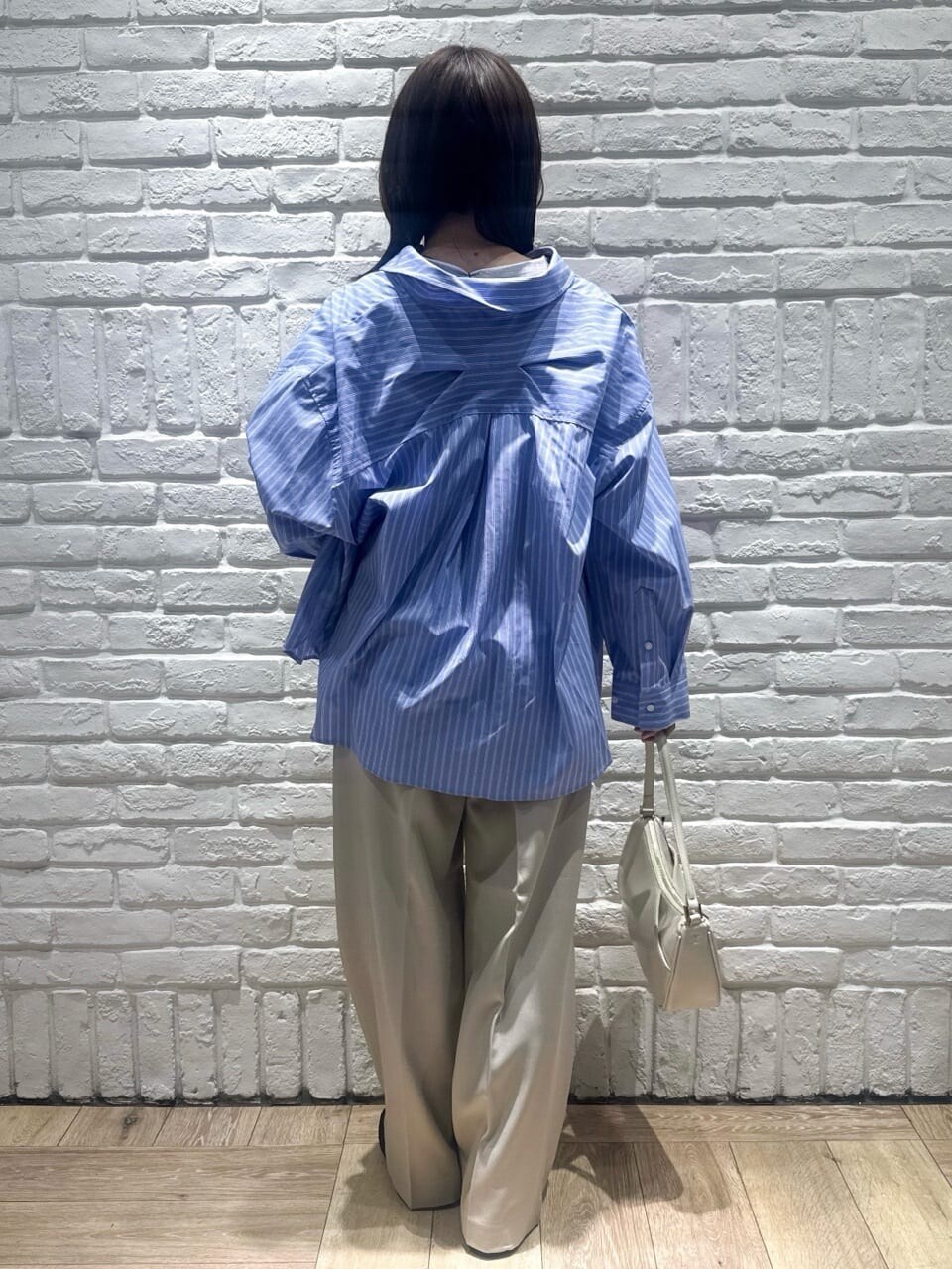 ブルー系のシャツ/ブラウス、グレー系のTシャツ/カットソー、ベージュ系のその他パンツを着用したレディースの春コーディネートの3枚目の写真