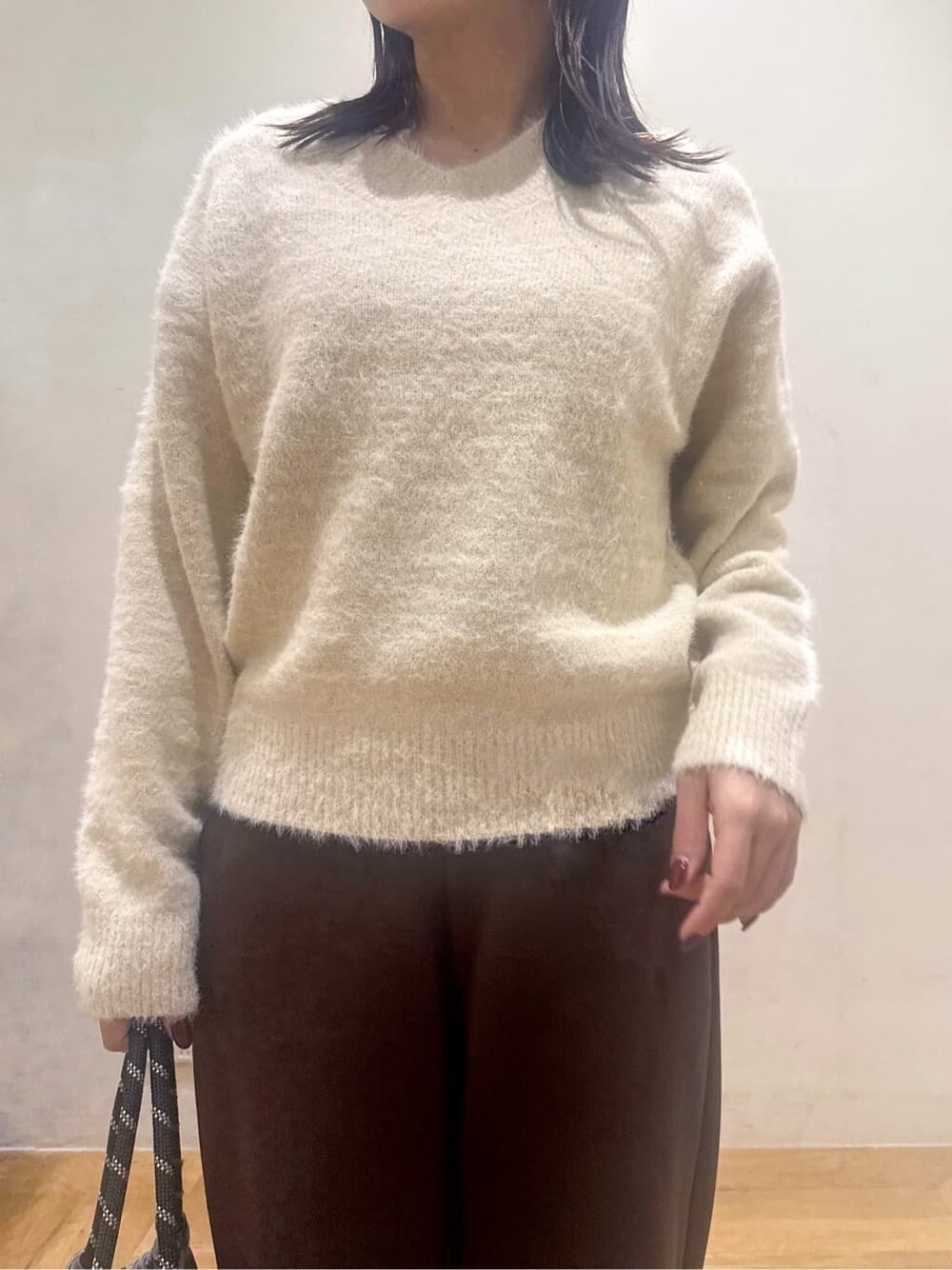 ベージュ系のニット/セーター、ブラウン系のその他パンツ、ブラック系のその他シューズを着用したレディースの冬コーディネートの2枚目の写真