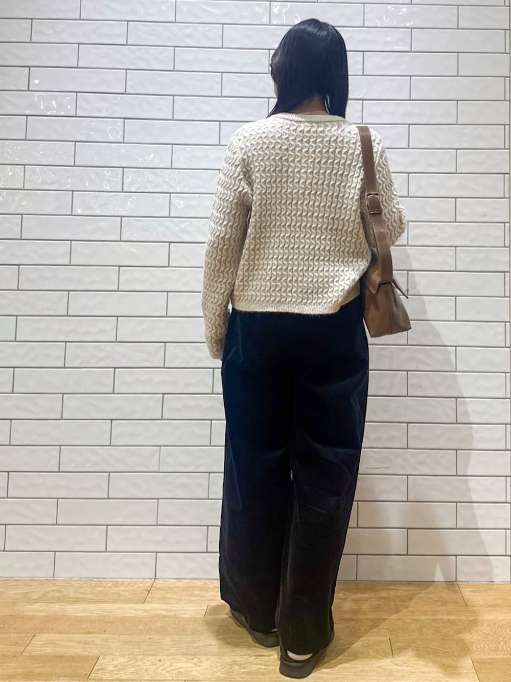 ホワイト系のカーディガン/ボレロ、ブラック系のその他パンツ、ブラウン系のボディバッグ/ウエストポーチを着用したレディースの冬コーディネートの3枚目の写真