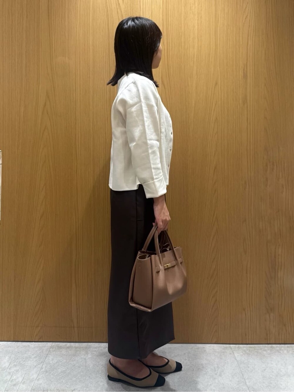 ホワイト系のカーディガン/ボレロ、ホワイト系のニット/セーター、ブラウン系のスカートを着用したレディースの夏コーディネートの3枚目の写真