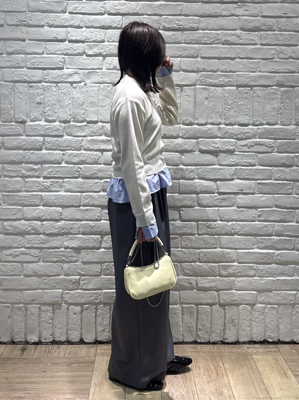 ホワイト系のカーディガン/ボレロ、グレー系のその他パンツ、イエロー系のショルダーバッグを着用したレディースの春コーディネートの2枚目の写真