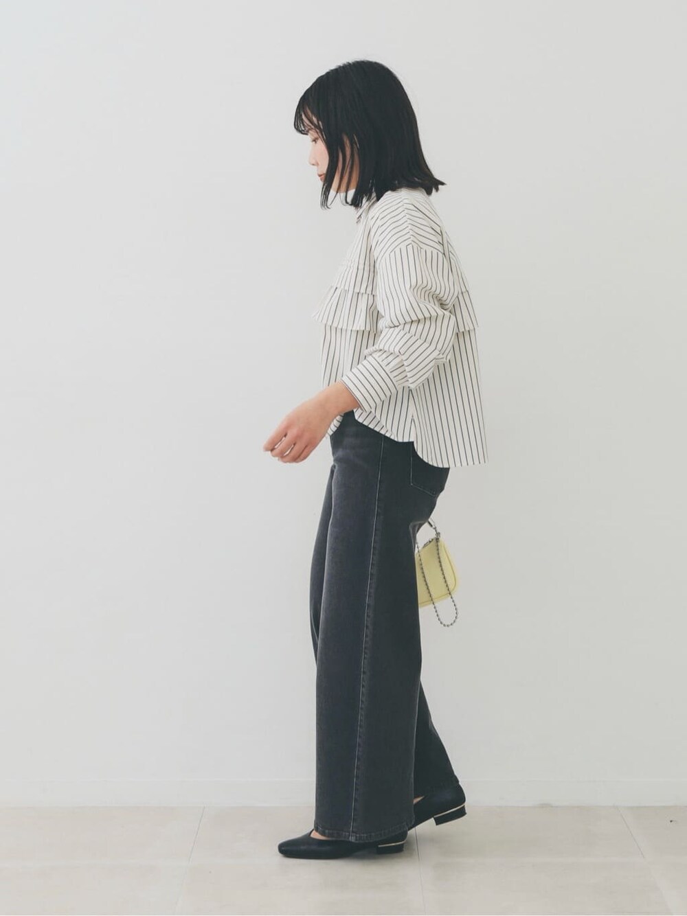 ベージュ系のシャツ/ブラウス、ホワイト系のニット/セーター、ブラック系のデニムパンツを着用したレディースの冬コーディネートの2枚目の写真