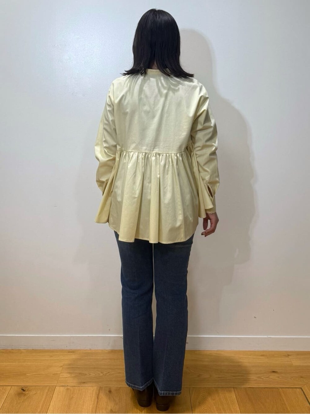 イエロー系のシャツ/ブラウス、ブルー系のデニムパンツ、ブラウン系のパンプスを着用したレディースの冬コーディネートの3枚目の写真
