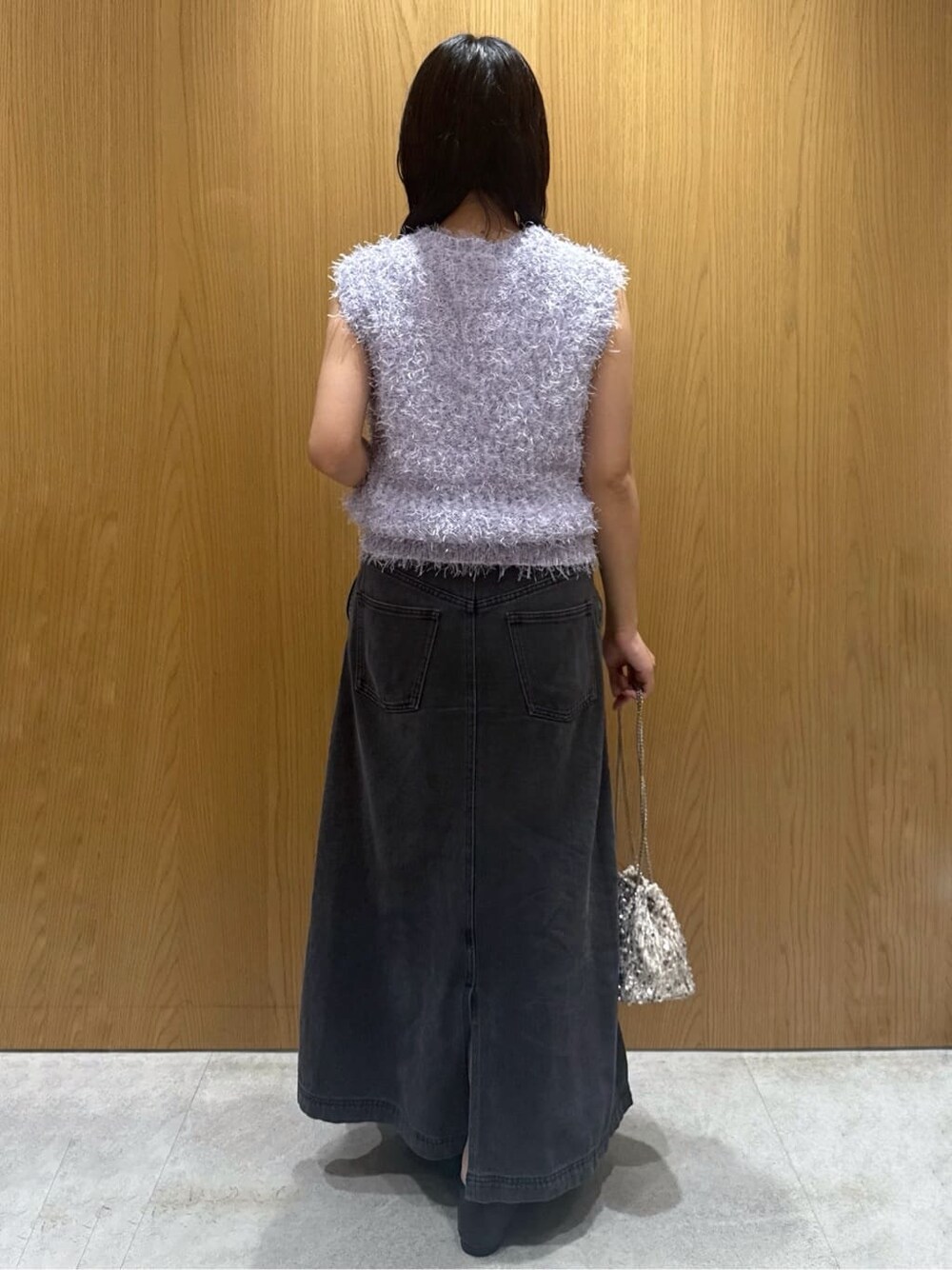 パープル系のベスト、ホワイト系のタンクトップ、ブラック系のデニムスカートを着用したレディースの夏コーディネートの3枚目の写真
