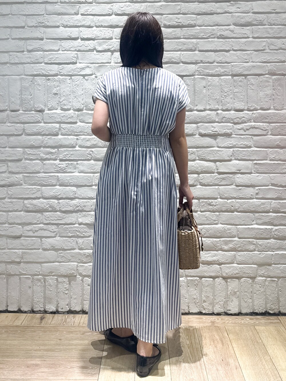 ブルー系のワンピース、ブラウン系のトートバッグ、ブラック系のパンプスを着用したレディースの夏コーディネートの3枚目の写真