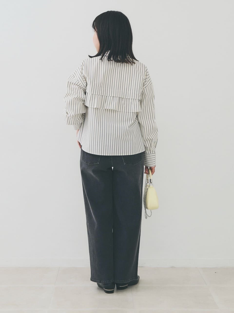 ベージュ系のシャツ/ブラウス、ホワイト系のニット/セーター、ブラック系のデニムパンツを着用したレディースの冬コーディネートの3枚目の写真
