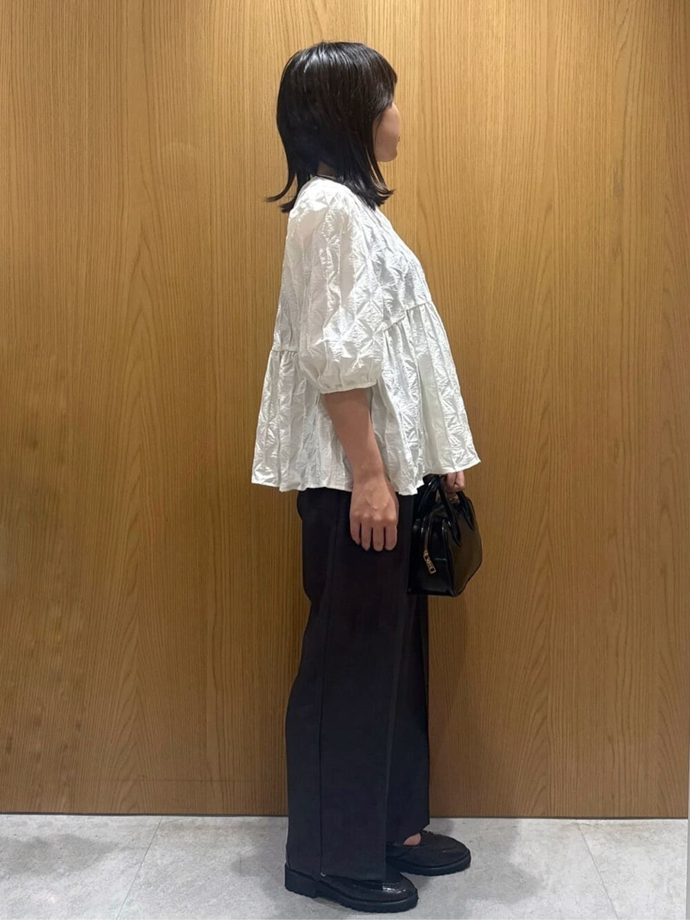 ホワイト系のシャツ/ブラウス、グレー系のその他パンツ、ブラック系のショルダーバッグを着用したレディースの秋コーディネートの2枚目の写真