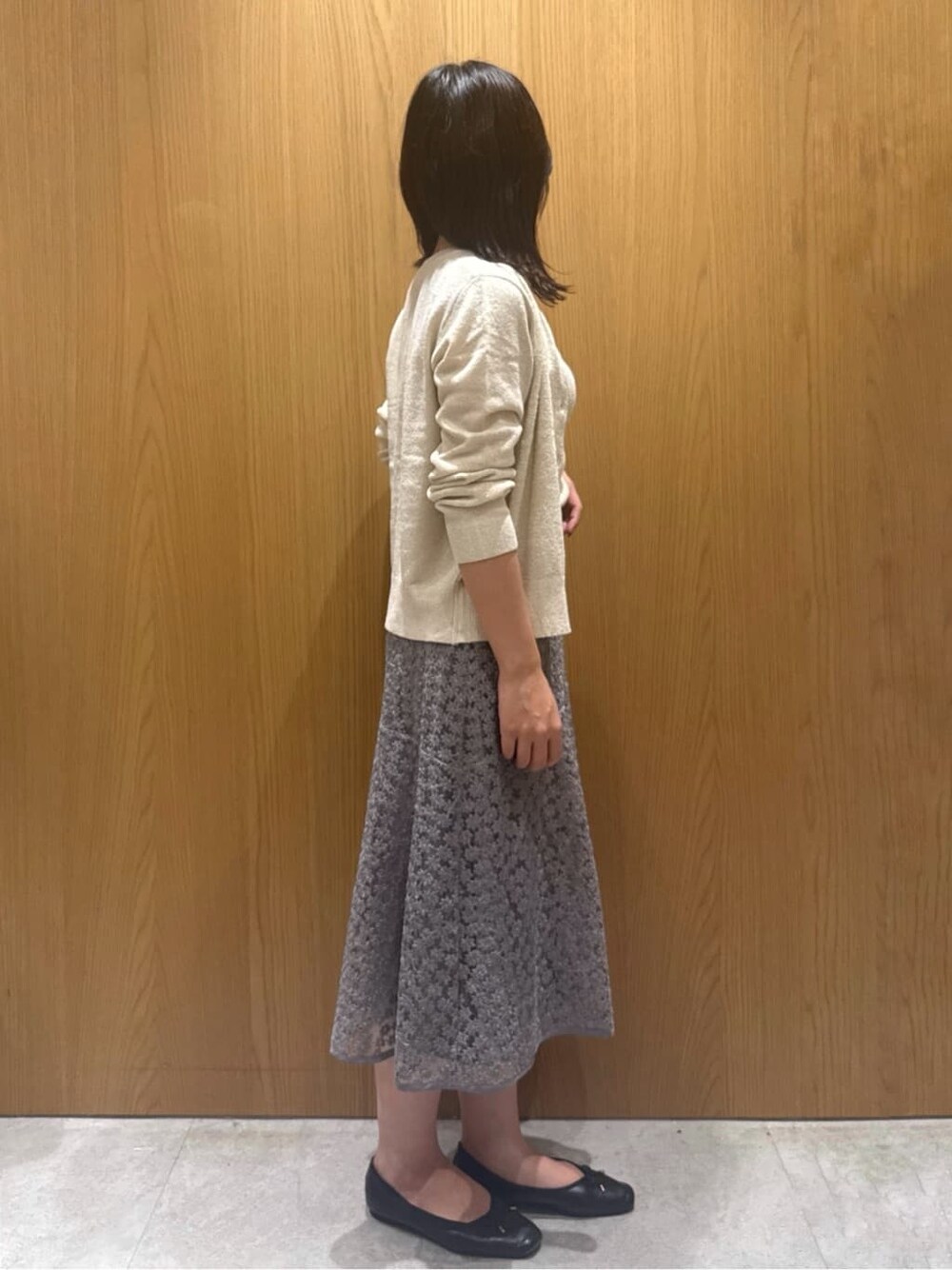 ホワイト系のカーディガン/ボレロ、ホワイト系のニット/セーター、グレー系のスカートを着用したレディースの秋コーディネートの2枚目の写真