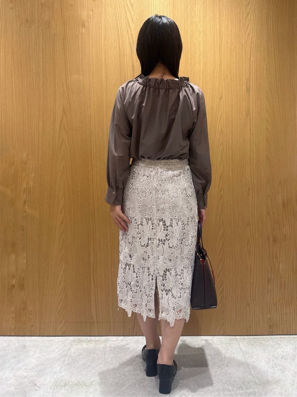 ブラウン系のシャツ/ブラウス、ベージュ系のスカート、ブラウン系のトートバッグを着用したレディースの秋コーディネートの2枚目の写真