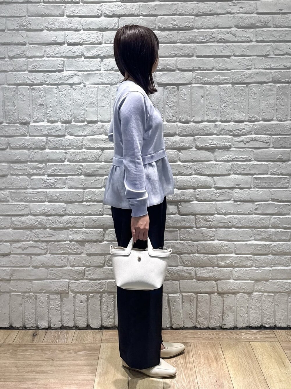 ブルー系のカーディガン/ボレロ、ブラック系のその他パンツ、ホワイト系のショルダーバッグを着用したレディースの春コーディネートの2枚目の写真