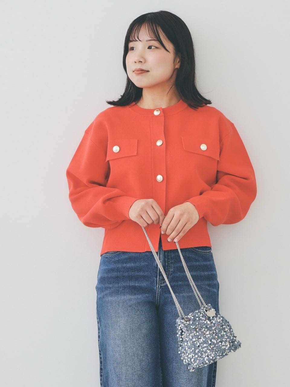 オレンジ系のカーディガン/ボレロ、ブルー系のデニムパンツ、グレー系のショルダーバッグを着用したレディースの冬コーディネートの5枚目の写真
