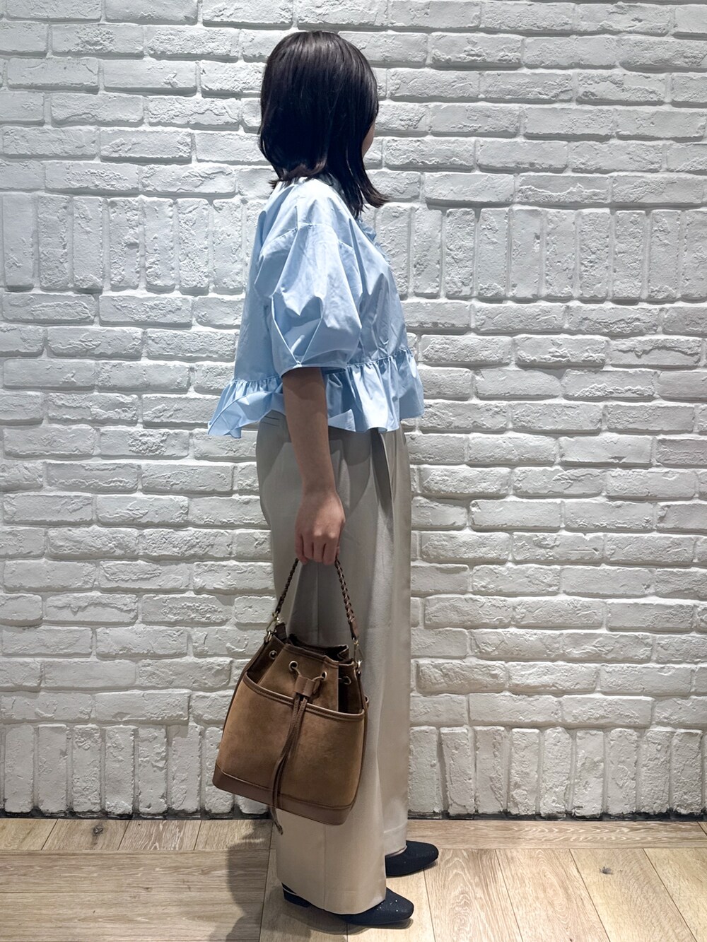 ブルー系のシャツ/ブラウス、ベージュ系のその他パンツ、ブラウン系のショルダーバッグを着用したレディースの春コーディネートの2枚目の写真