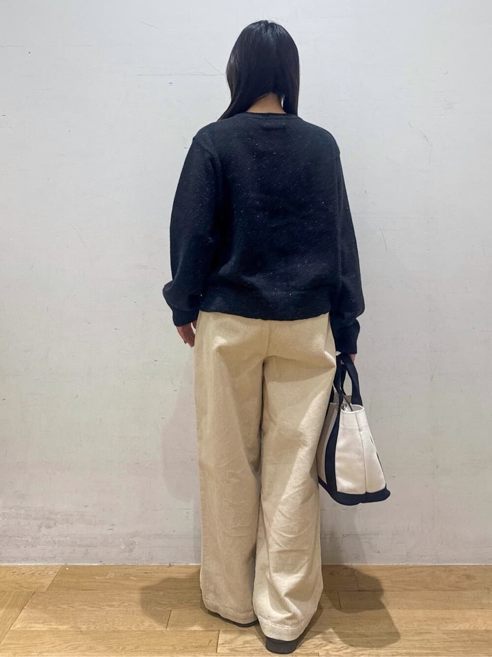 ブラック系のカーディガン/ボレロ、ホワイト系のその他パンツ、ベージュ系のトートバッグを着用したレディースの冬コーディネートの3枚目の写真