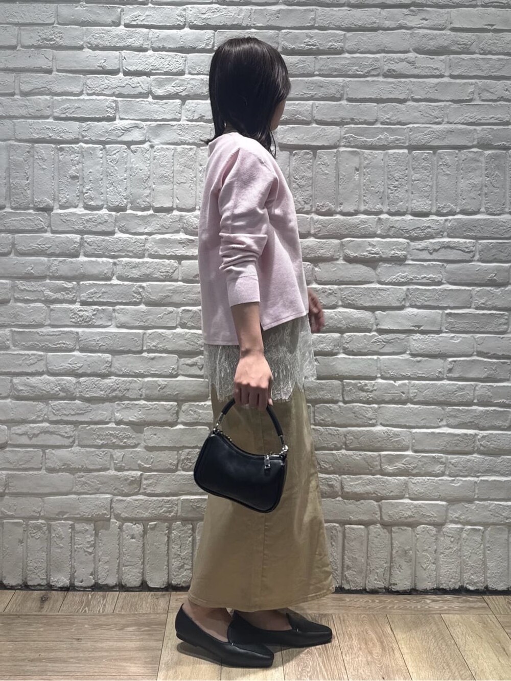 ピンク系のニット/セーター、ホワイト系のタンクトップ、ベージュ系のスカートを着用したレディースの春コーディネートの2枚目の写真