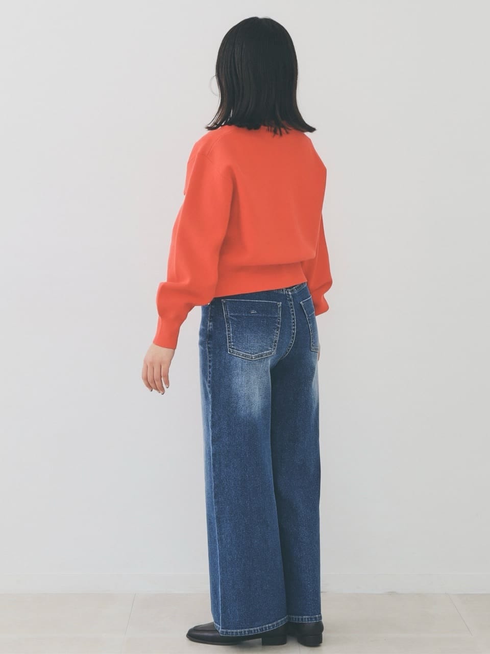 オレンジ系のカーディガン/ボレロ、ブルー系のデニムパンツ、グレー系のショルダーバッグを着用したレディースの冬コーディネートの2枚目の写真