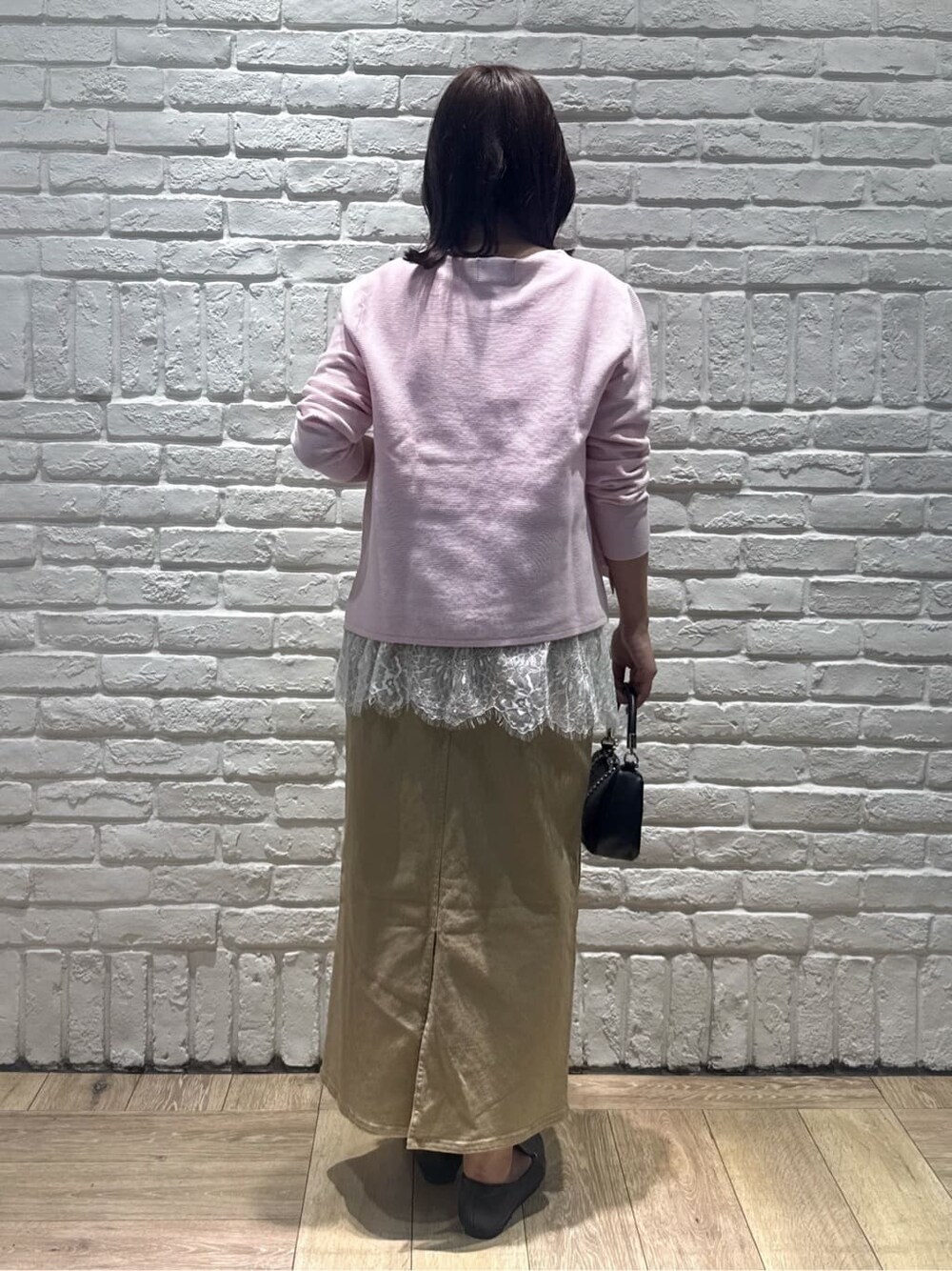 ピンク系のニット/セーター、ホワイト系のタンクトップ、ベージュ系のスカートを着用したレディースの春コーディネートの3枚目の写真