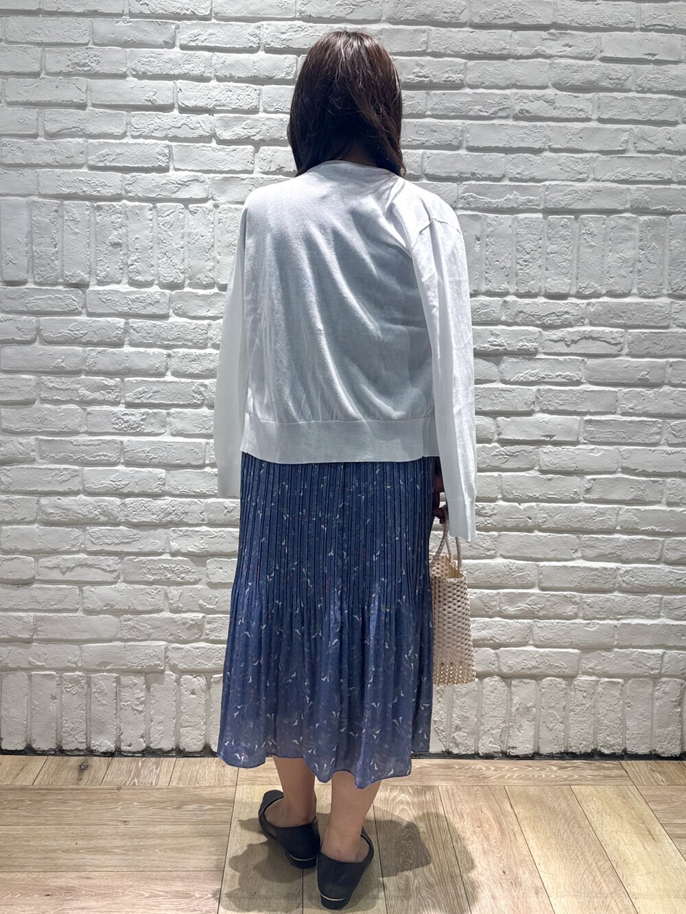 ブルー系のワンピース、ホワイト系のカーディガン/ボレロ、ゴールド系のトートバッグを着用したレディースの春コーディネートの3枚目の写真