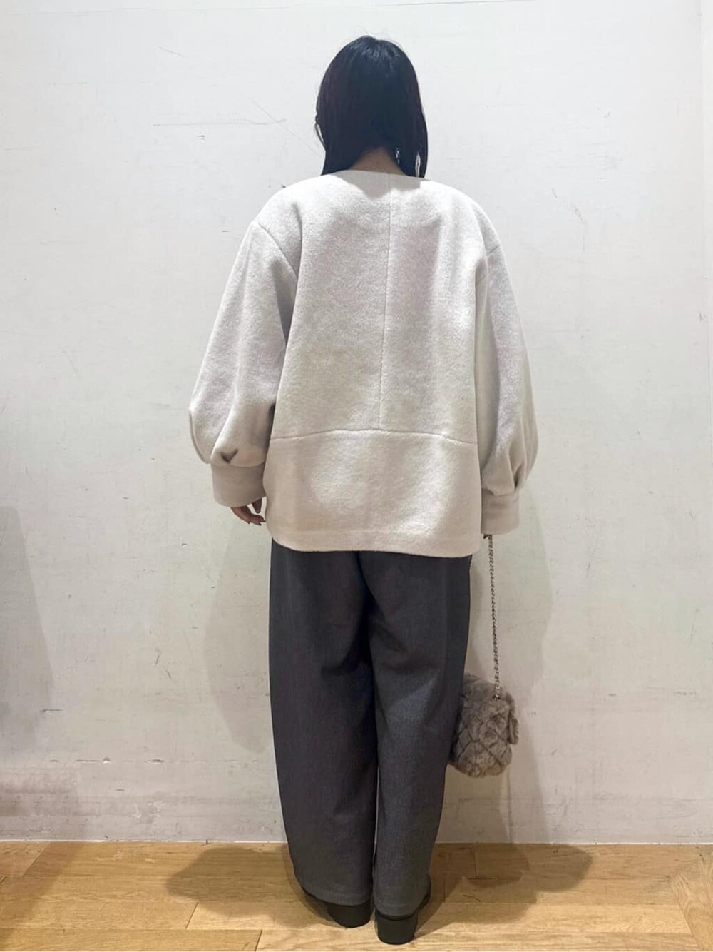 ベージュ系のノーカラーコート、ブラック系のニット/セーター、グレー系のその他パンツを着用したレディースの秋コーディネートの3枚目の写真