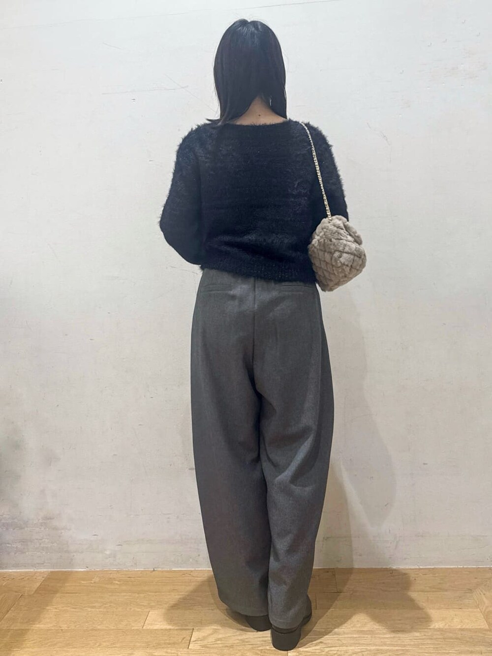 ブラック系のニット/セーター、グレー系のその他パンツ、ブラック系のブーツを着用したレディースの秋コーディネートの3枚目の写真