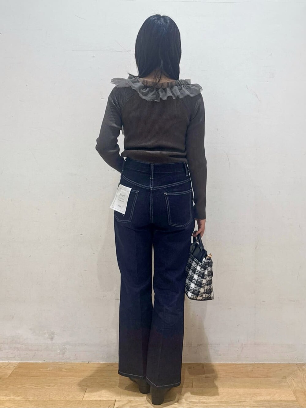 グレー系のニット/セーター、ブルー系のその他パンツ、ブラック系のハンドバッグを着用したレディースの秋コーディネートの3枚目の写真