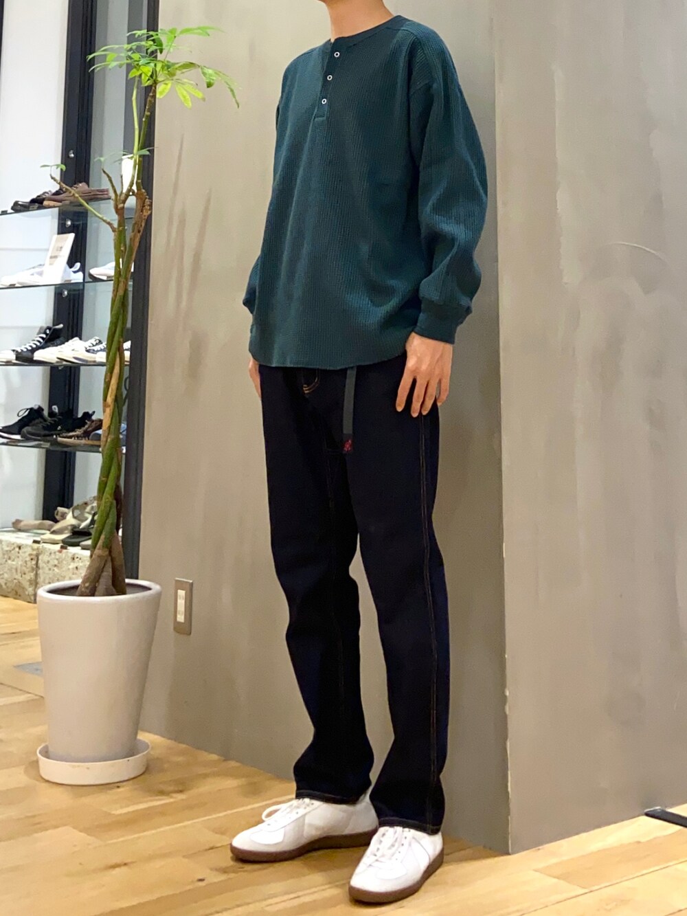 グリーン系のTシャツ/カットソー、ブルー系のその他パンツ、ホワイト系のスニーカーを着用したメンズの秋コーディネートの2枚目の写真