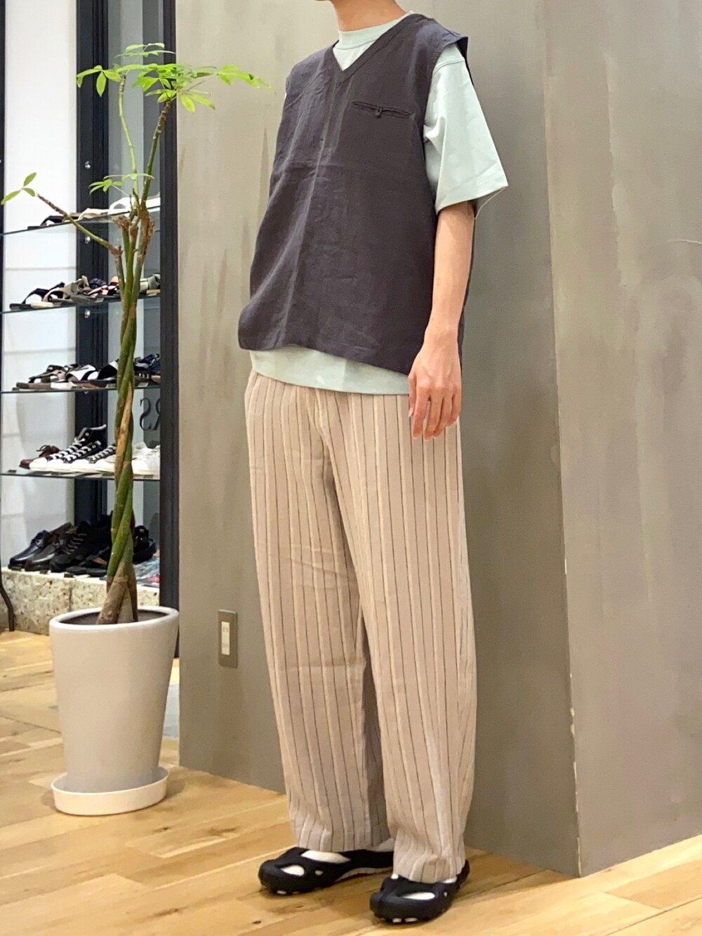 ブラック系のベスト、グリーン系のTシャツ/カットソー、ベージュ系のその他パンツを着用したメンズの夏コーディネートの2枚目の写真