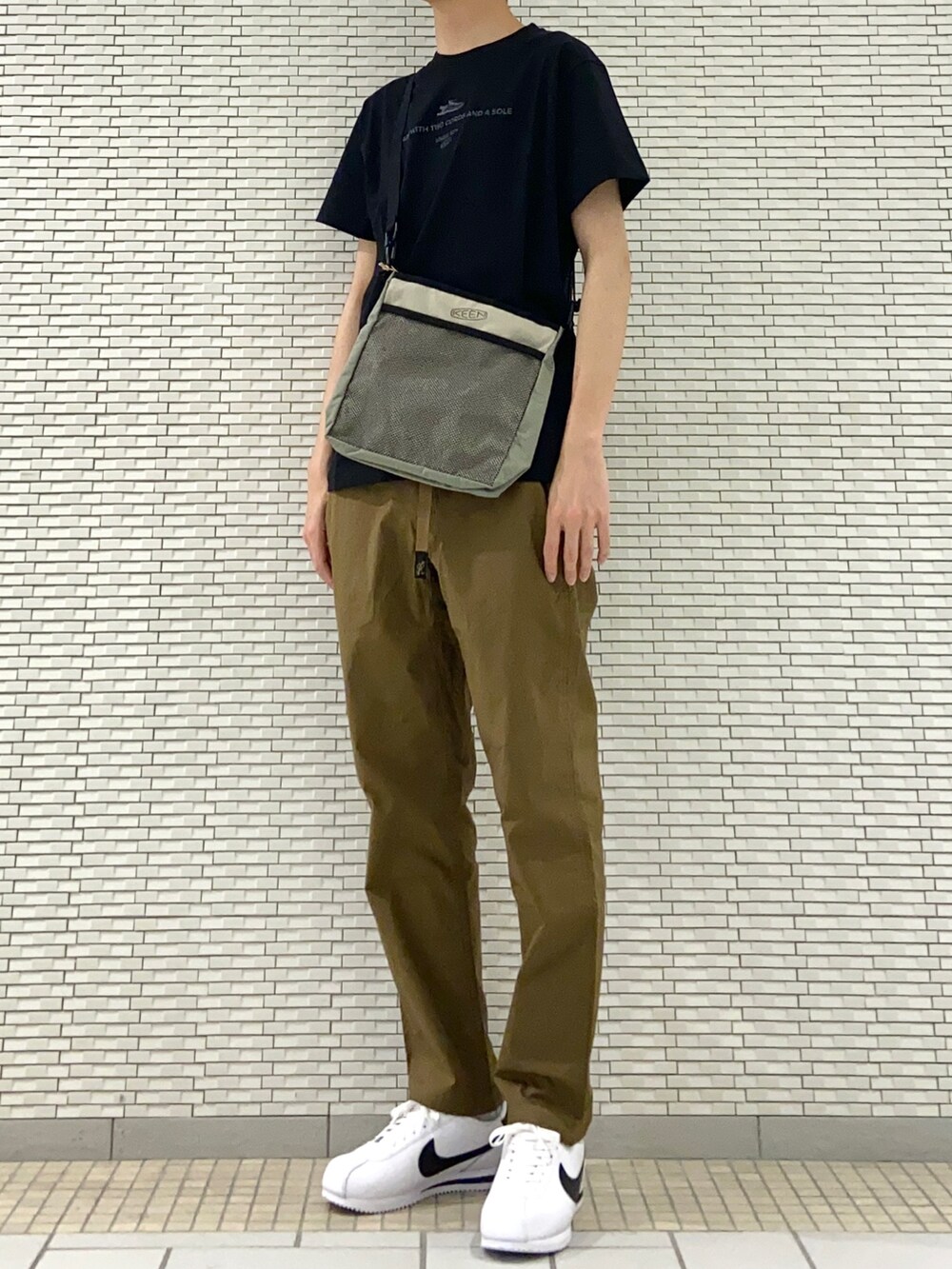 ブラック系のTシャツ/カットソー、ベージュ系のショルダーバッグ、ブラック系のその他パンツを着用したメンズの春コーディネートの2枚目の写真
