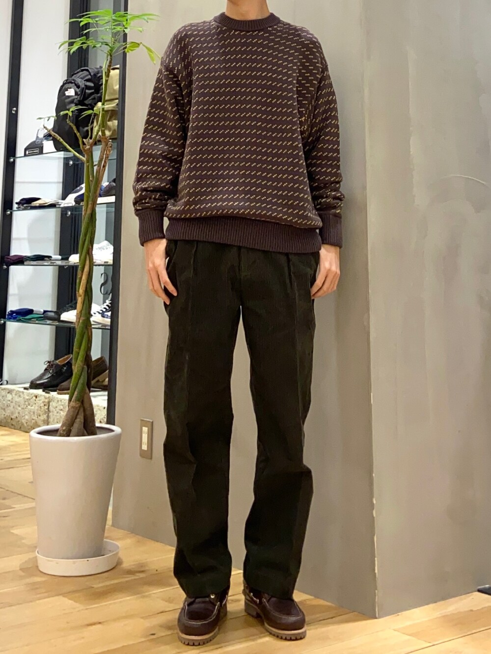 グレー系のブルゾン、ブラウン系のニット/セーター、ブラウン系のスニーカーを着用したメンズの冬コーディネートの2枚目の写真