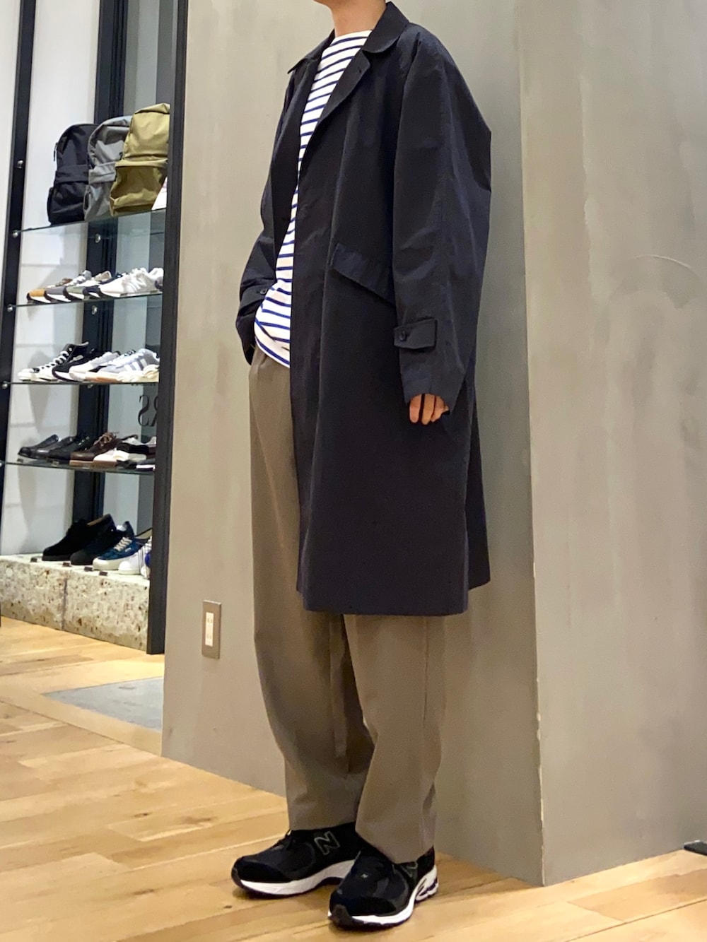 ブルー系のステンカラーコート、ブルー系のTシャツ/カットソー、ブラウン系のその他パンツを着用したメンズの春コーディネートの3枚目の写真