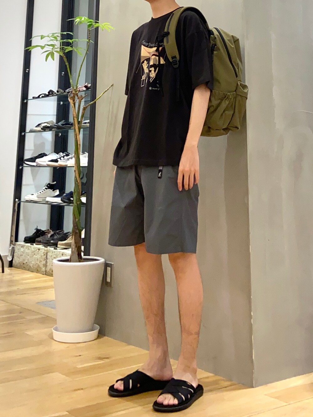 ブラック系のTシャツ/カットソー、グレー系のその他パンツ、ブラック系のサンダルを着用したメンズの夏コーディネートの2枚目の写真