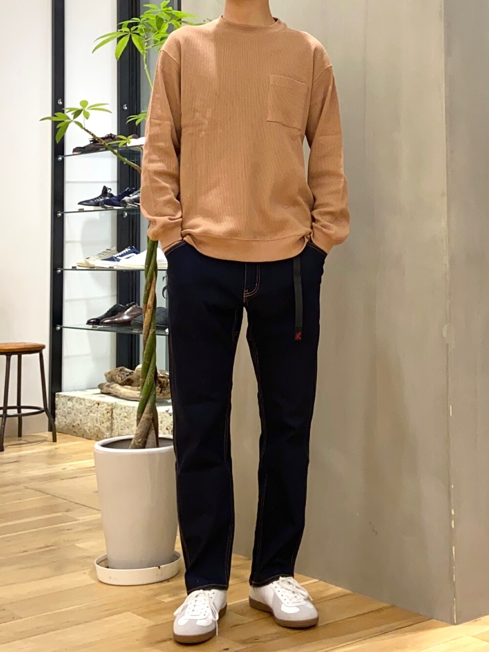 ブラウン系のダウンジャケット/コート、オレンジ系のTシャツ/カットソー、ブルー系のその他パンツを着用したメンズの冬コーディネートの2枚目の写真