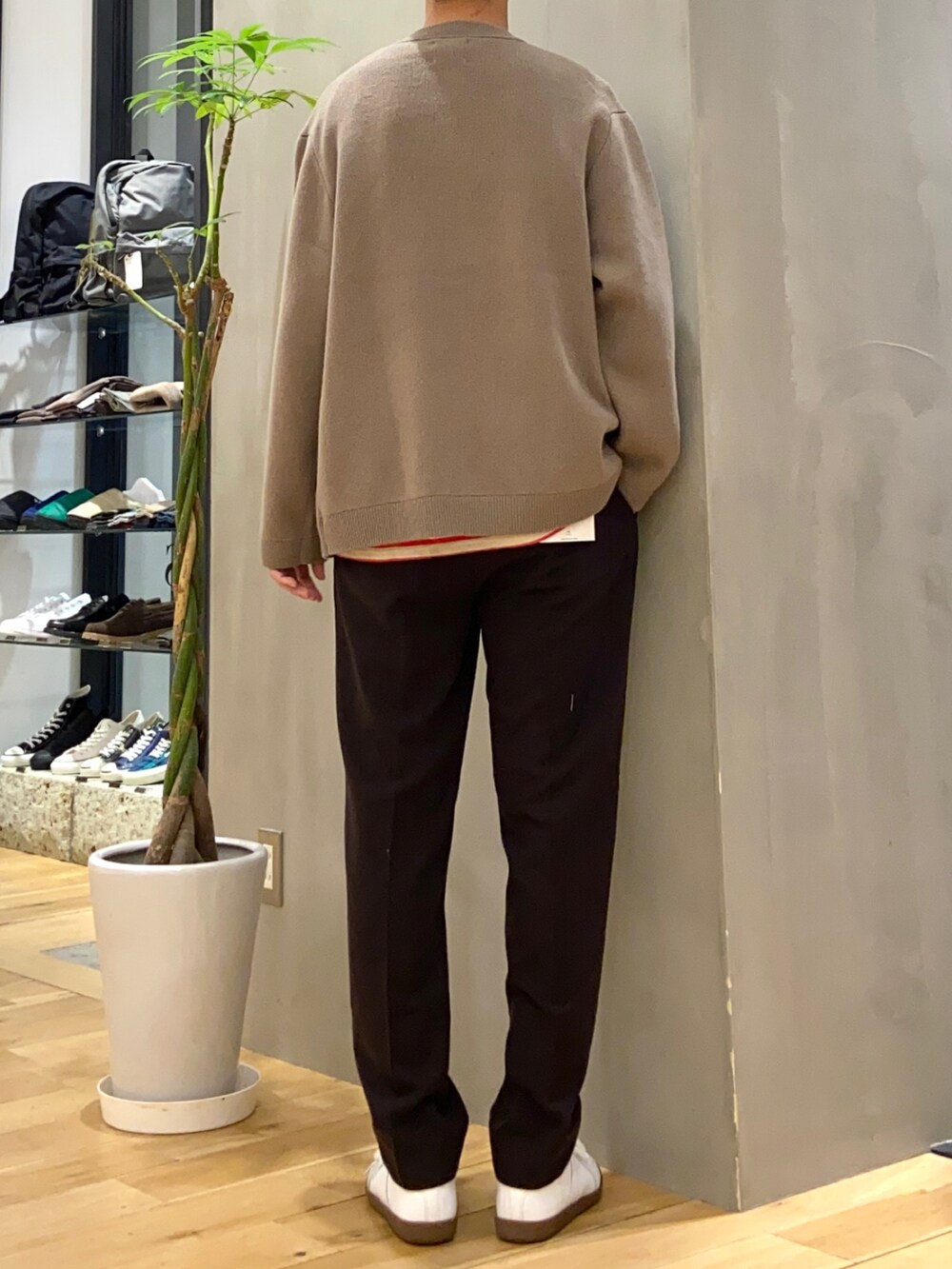 ブラウン系のカーディガン/ボレロ、グレー系のTシャツ/カットソー、ホワイト系のスニーカーを着用したメンズの冬コーディネートの3枚目の写真